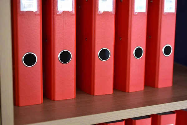 Office red folders on the shelf in the office