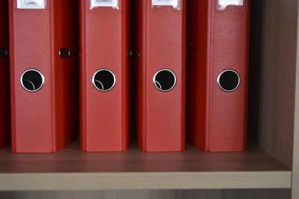 Office red folders on the shelf in the office