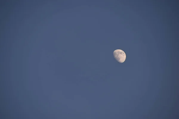 White moon in a blue sky in summer