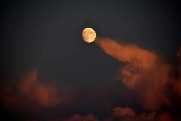 Full moon and clouds in the late evening