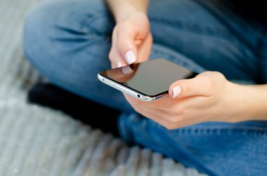 Genç bir kız cep telefonunu kullanıyor. Uzaktan iletişim.