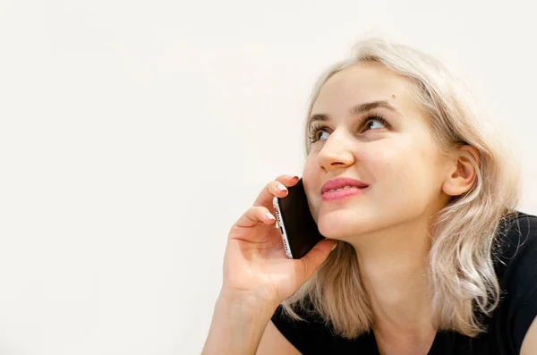 Una joven con el pelo rubio se comunica por teléfono. —  Fotos de Stock