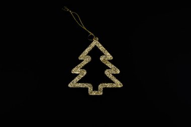 Siyah arka planda minimalist altın Noel ağacı. Yeni yıl basit kompozisyon. Mutlu Noeller ve mutlu yıllar tebrik kartı..