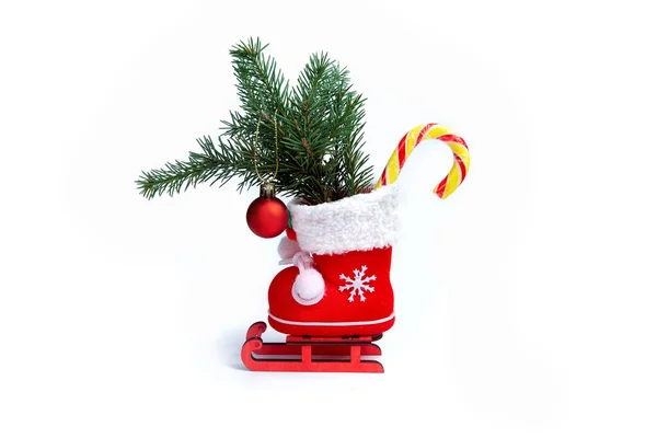 Hediyeli kırmızı Noel çizmesi, lolipop ve Noel kızağında kırmızı Noel balosu. Beyaz arkaplan.