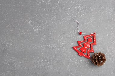 Gri arka planda konisi olan minimalist kırmızı ahşap Noel ağacı. Yeni yıl basit kompozisyon. Mutlu Noeller ve mutlu yıllar tebrik kartı..