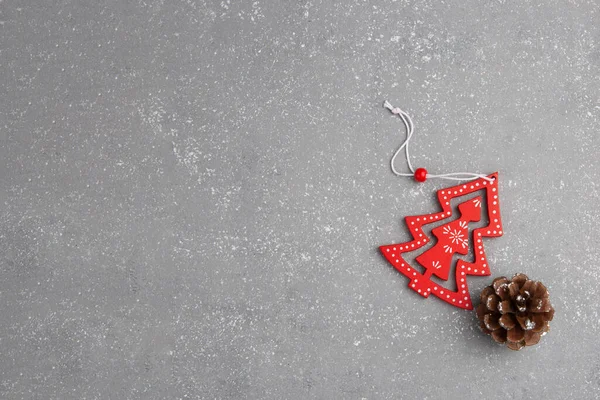 Gri arka planda konisi olan minimalist kırmızı ahşap Noel ağacı. Yeni yıl basit kompozisyon. Mutlu Noeller ve mutlu yıllar tebrik kartı..