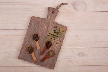 Ahşap kaşık kesme tahtasının üzerinde eski mutfak aletleri ve baharatlar. Yemek pişirme konsepti. Üst görünüm.