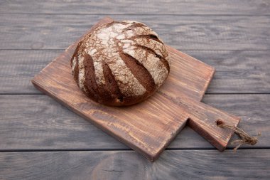 Köy ahşabından yapılmış bir bıçakla ahşap bir tahtanın üzerinde çavdar ekmeği. Üst görünüm.