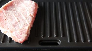 Cooking raw meat steaks in grilled sauce by the chef.