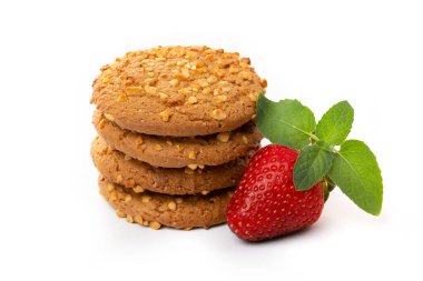 Beyaz zemin üzerinde çilekli ve yeşil nane yaprağı olan yulaflı kurabiyeler. Diyet yemek..