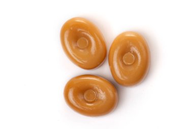 Beyaz arka planda üç karamel şekeri..