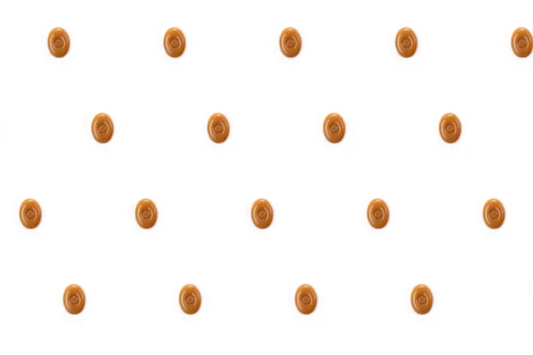 Ein Muster Ovaler Karamellbonbons Auf Weißem Hintergrund — Stockfoto