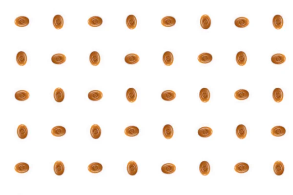 Ein Muster Aus Ineinandergreifenden Ovalen Karamellbonbons Auf Weißem Hintergrund — Stockfoto