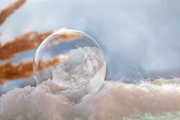 雪の上の美しいパターンを持つ冷凍石鹸バブルぼやけた背景にクローズアップ — ストック写真