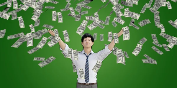 Asiatischer Mann fängt Geld, das vom Himmel fällt — Stockfoto