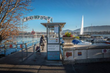 Geneva, Switzerland - December 06, 2019: Bains des Paquis Public Baths at Lake Geneva and Jet dEau Water Fountain clipart