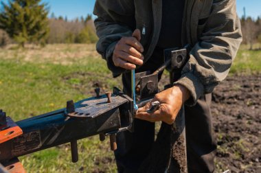 Yaşlı bir adam toprağı sürüyor.