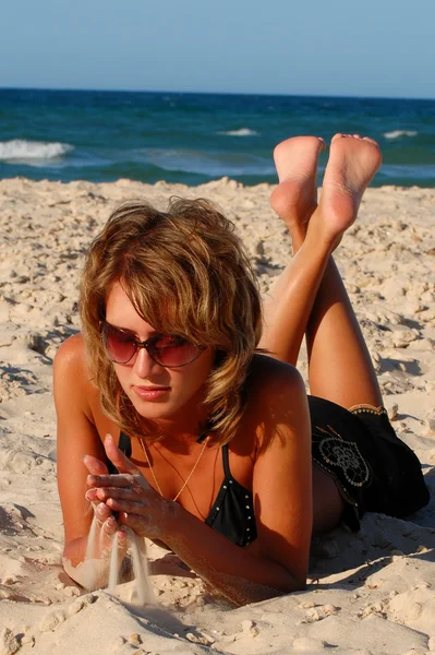 Chica acostada en la arena junto al mar — Foto de Stock