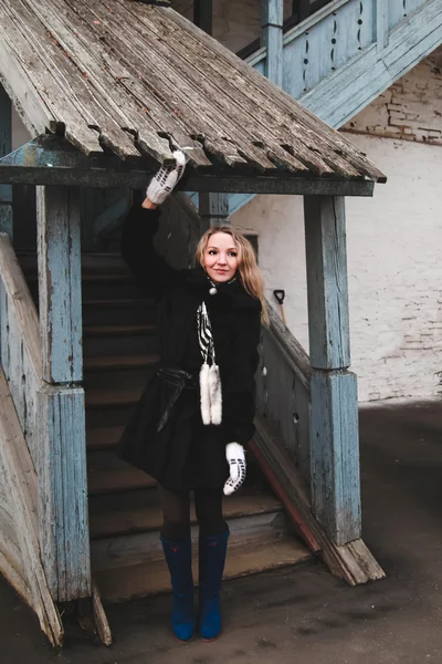 Girl in a fur coat on the stairs — Stock Photo, Image