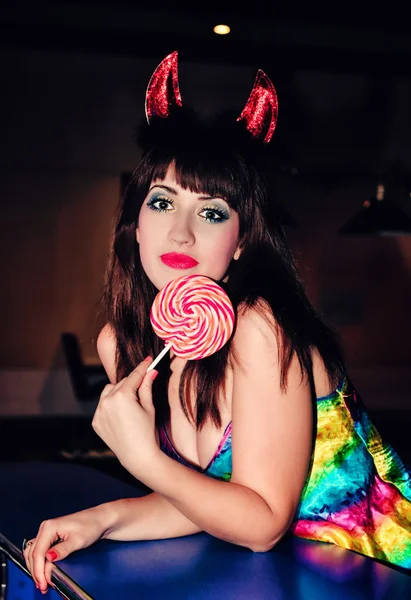 Chica con dulces en un traje de diablo — Foto de Stock