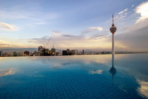 Hermoso reflejo de la Torre Kuala Lumpur junto a la piscina por la noche . — Foto de Stock