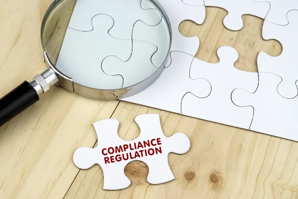 İş kavramı. Büyüteç ahşap arka plan jigsaw bulmaca üzerinde