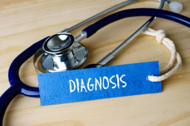 Ahşap arka plan üzerinde Tanı kelimeleri ve stetoskop ile görüntü.