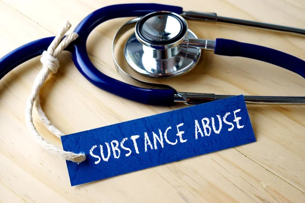 Substance Abuse word geschreven op LabelTag en stethoscoop op houten achtergrond. — Stockfoto
