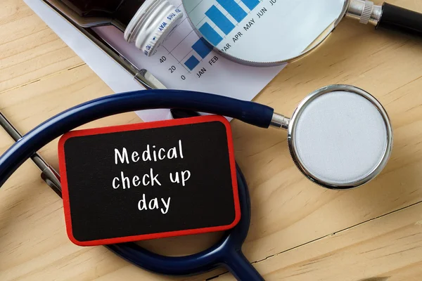 Стетоскоп на деревянном столе со словом MEDICAL CHECK UP DAY . — стоковое фото