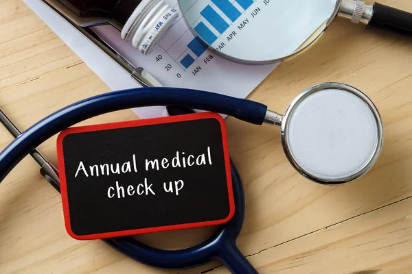 Stetoskop w drewniany stół z word roczne medyczne Sprawdź się. — Zdjęcie stockowe