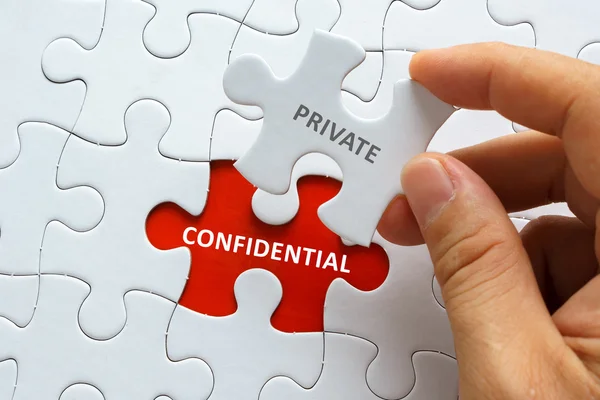 Piece of blank jigsaw puzzle with word PRIVATE CONFIDENTIAL. — Stock Photo, Image