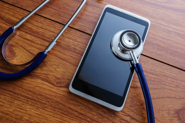 Smartphone mit Stethoskop auf Holzgrund diagnostiziert. — Stockfoto