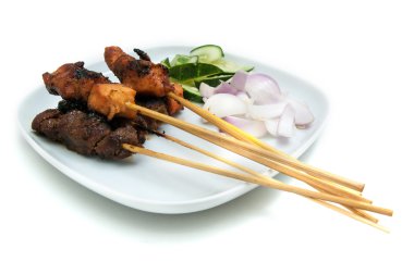 Beyaz tabakta lezzetli satay salatalık ve soğan ile