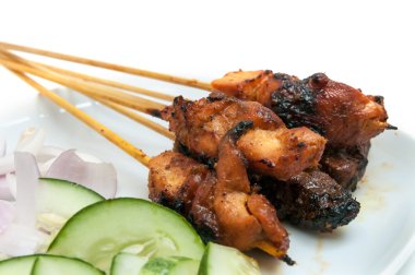 Beyaz tabakta lezzetli satay salatalık ve soğan ile