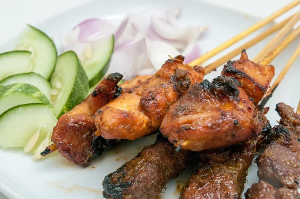 Delicioso satay con pepinos y cebollas servidos en plato blanco —  Fotos de Stock