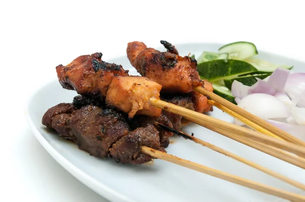 Delicioso satay con pepinos y cebollas servidos en plato blanco —  Fotos de Stock