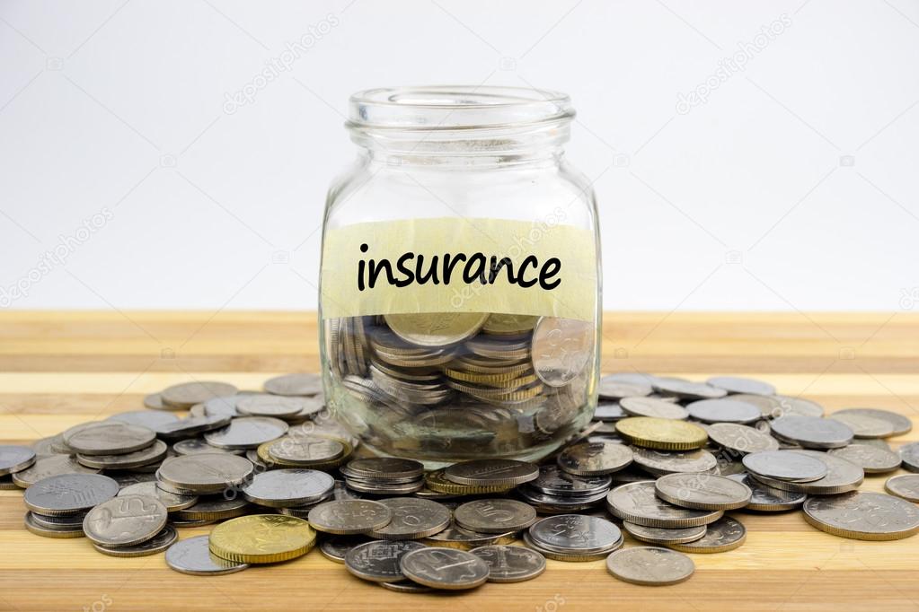 Coins in glass container on wooden surface