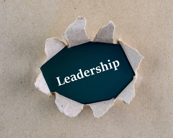 Gescheurd bruin ruw geweven papier met "leiderschap" woord op achtergrond oppervlak. — Stockfoto