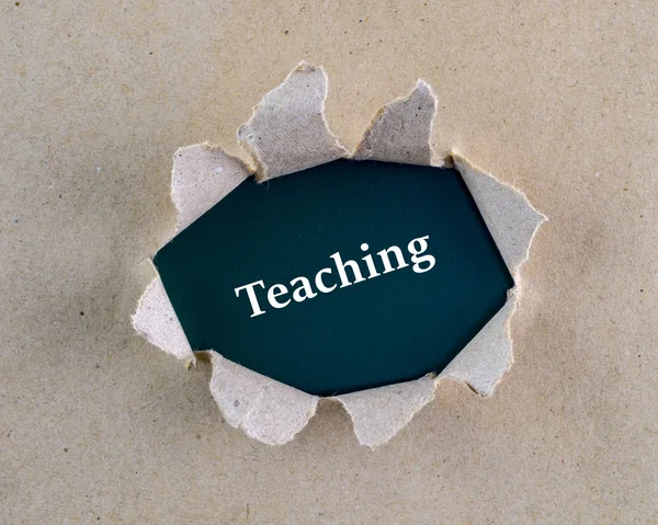 Torn brown rough textured paper with "Teaching" word at background surface. — Stock Photo, Image