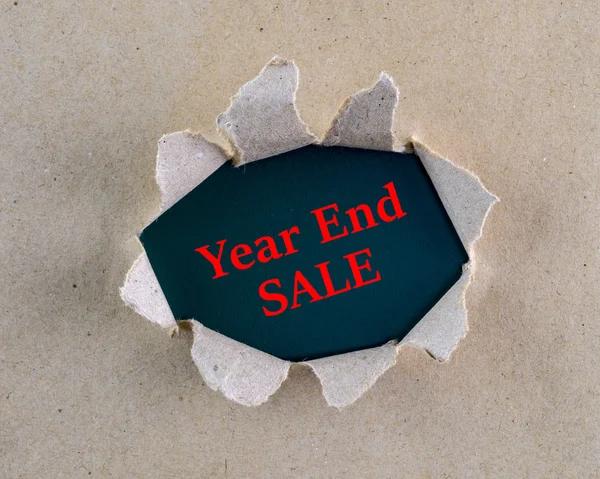 Strappato marrone carta ruvida testurizzata con parole "fine anno di vendita" sulla superficie di sfondo . — Foto Stock