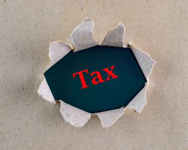 背景表面に「税金」の単語を持つ破れた茶色の粗いテクスチャペーパー. — ストック写真