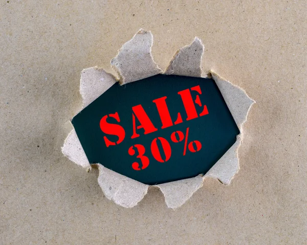 Roztrhaný hnědý hrubý papír s nápisem "prodej 30%" na pozadí. — Stock fotografie