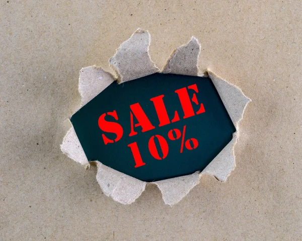 Zerrissenes braunes grob strukturiertes Papier mit "Sale 10%" -Wörtern auf der Hintergrundoberfläche. — Stockfoto