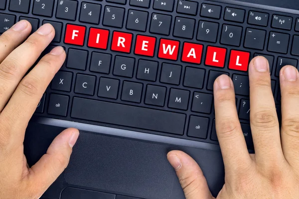 Mâinile pe laptop cu cuvântul "FIREWALL" pe butoanele tastaturii . — Fotografie, imagine de stoc