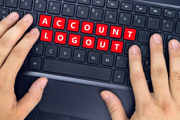 Hænder på bærbar computer med "ACCOUNT LOGOUT" ord på tastaturknapper . - Stock-foto
