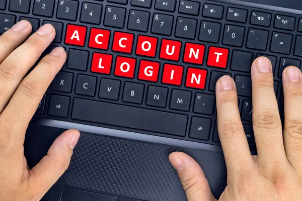 Hænder på bærbar computer med "ACCOUNT LOGIN" ord på tastaturknapper . - Stock-foto