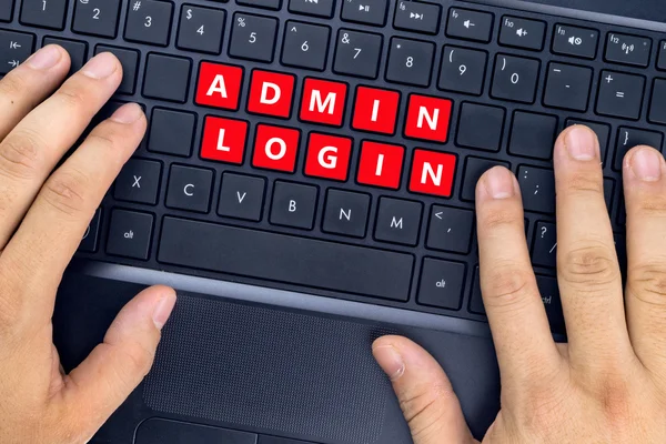 Hænder på bærbar computer med "ADMIN LOGIN" ord på tastaturknapper . - Stock-foto