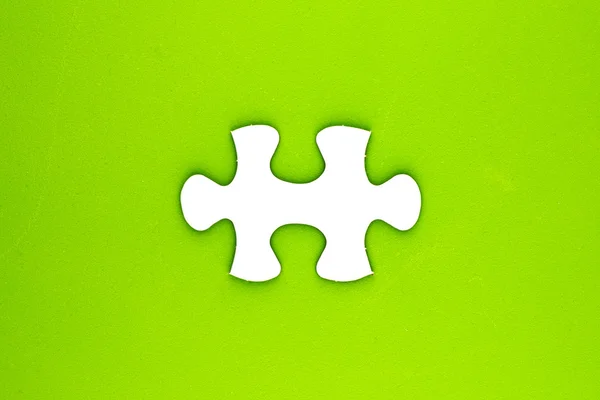 Stuk van de puzzel op ruw groene oppervlak. — Stockfoto