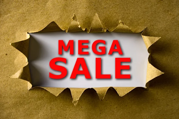 Порванная коричневая бумага со словами MEGA SALE — стоковое фото