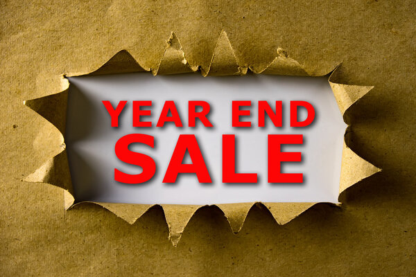 Torn brown paper with YEAR END SALE words
